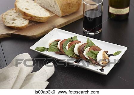 Stock Image - Still life of mozzarella salad and sliced bread. Fotosearch