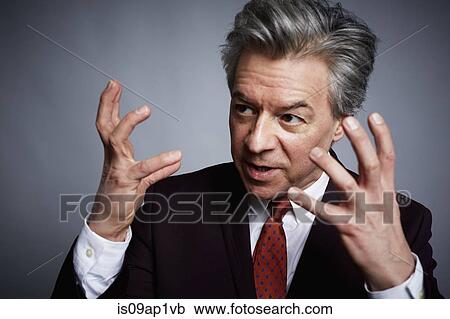 Studio portrait of mature businessman with hands open in explanation View Large Photo Image Stock Image - Studio portrait of mature businessman with hands open in explanation. Fotosearch