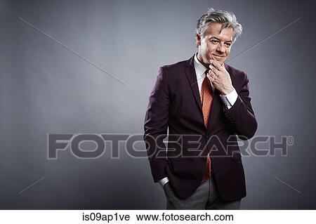 Studio portrait of mature businessman with hand on chin View Large Photo Image Stock Image - Studio portrait of mature businessman with hand on chin. Fotosearch