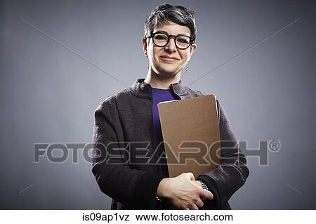 Stock Photo - Studio portrait of mature businesswoman with clipboard. Fotosearch