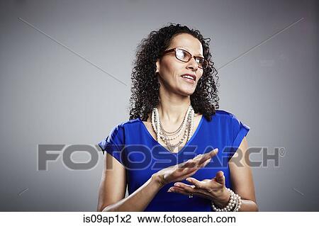 Stock Image - Studio portrait of mature woman clapping. Fotosearch