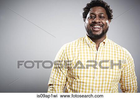Stock Image - Studio portrait of mid adult businessman laughing. Fotosearch