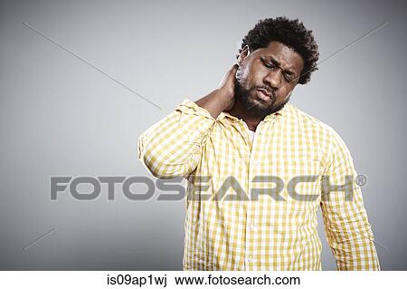 Studio portrait of mid adult businessman massaging neck View Large Photo Image Stock Image - Studio portrait of mid adult businessman massaging neck. Fotosearch