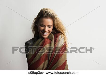 Stock Photo - Studio portrait of shy young woman wrapped in American flag. Fotosearch