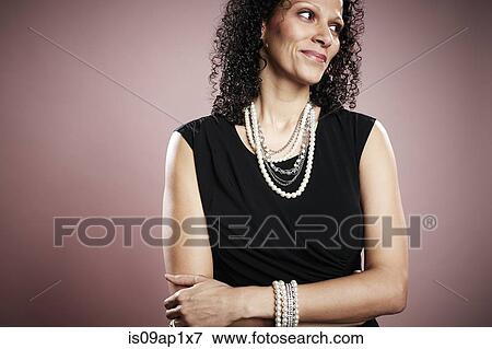 Stock Photo - Studio portrait of smiling mature woman looking sideways. Fotosearch