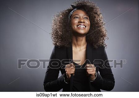 Stock Photograph - Studio portrait of young businesswoman with fists clenched. Fotosearch