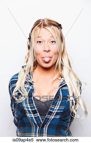 Studio portrait of young woman with long blond hair sticking tongue out View Large Photo Image Stock Photography - Studio portrait of young woman with long blond hair sticking tongue out. Fotosearch