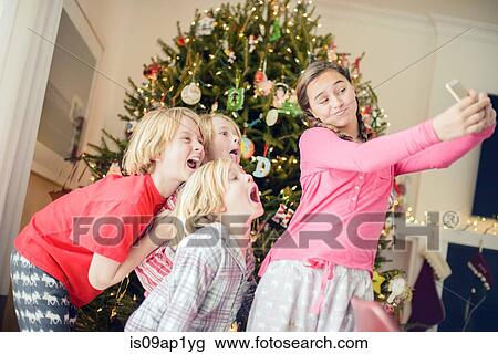 Teenage girl and brothers taking smartphone selfie at christmas View Large Photo Image Stock Image - Teenage girl and brothers taking smartphone selfie at christmas. Fotosearch