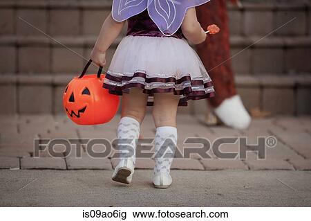 Toddler carrying Jack O' Lantern bucket View Large Photo Image Stock Image - Toddler carrying Jack O' Lantern bucket. Fotosearch