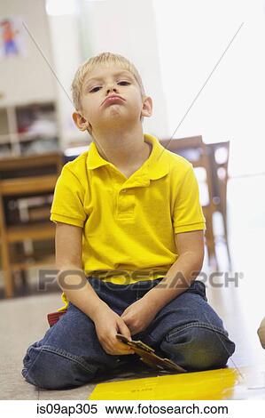 Stock Photography - Toddler sulking in classroom. Fotosearch