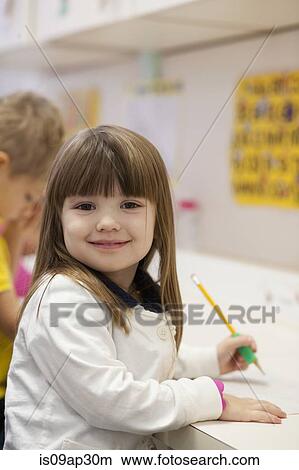 Picture - Toddler writing in classroom. Fotosearch
