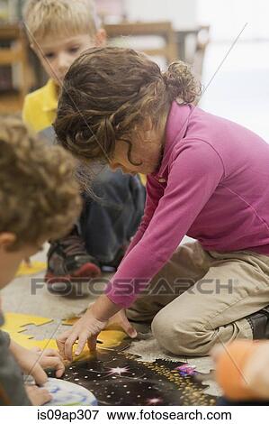 Toddlers playing jigsaw puzzle in classroom View Large Photo Image Stock Photo - Toddlers playing jigsaw puzzle in classroom. Fotosearch