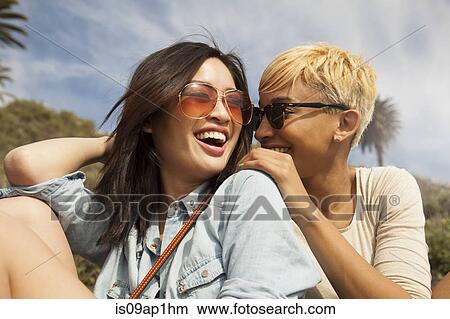 Picture - "Two female friends, outdoors, laughing together". Fotosearch