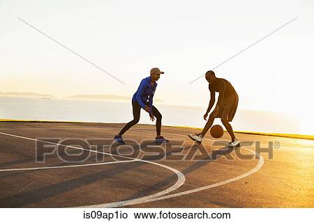 Picture - "Two friends playing basketball, outdoors". Fotosearch