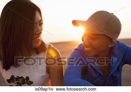 "Two young women outdoors, smiling" View Large Photo Image Stock Photo - "Two young women outdoors, smiling". Fotosearch