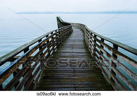 Stock Image - "View of winding wooden pier on Puget Sound, Seattle, Washington State, USA". Fotosearch