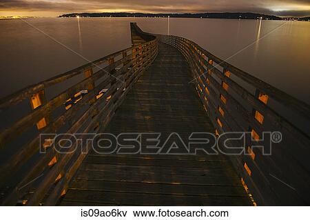 Stock Photo - "View of winding wooden pier over Puget Sound at night, Seattle, Washington State, USA". Fotosearch