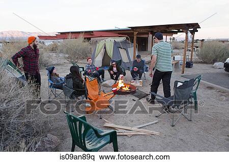 Stock Photography - "Young adult friends sitting chatting around campfire, Anza-Borrego Desert State Park, California, USA". Fotosearch