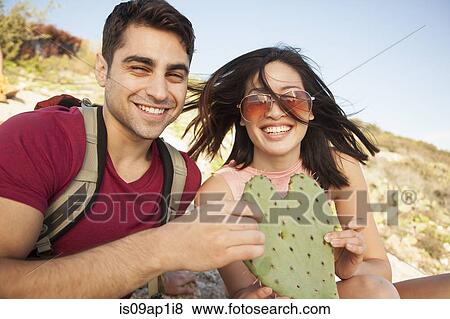 Young couple holding heart shaped cactus leaf View Large Photo Image Stock Photo - Young couple holding heart shaped cactus leaf. Fotosearch