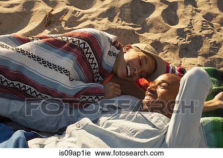 Young couple lying together on beach View Large Photo Image Stock Image - Young couple lying together on beach. Fotosearch