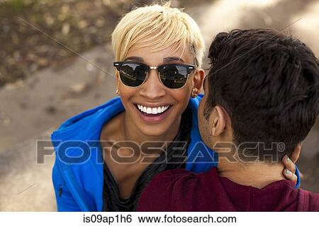 Stock Photograph - "Young couple sitting, outdoors, elevated view". Fotosearch