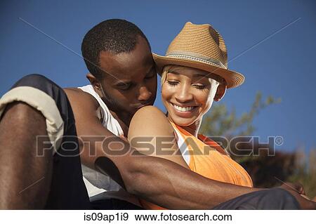 Stock Photo - "Young couple, sitting together, flirting, outdoors". Fotosearch