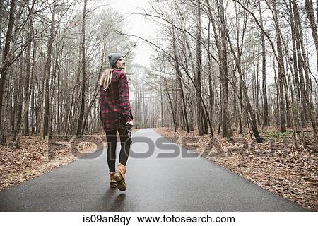 Young female photographer looking over her shoulder on rural forest road View Large Photo Image Stock Photo - Young female photographer looking over her shoulder on rural forest road. Fotosearch