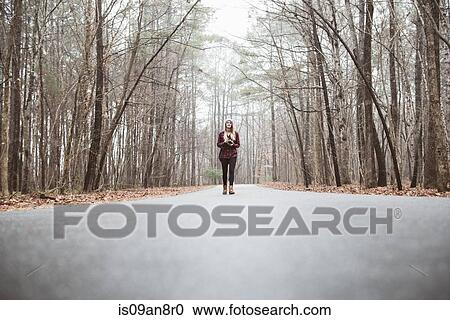 Young female photographer standing on rural forest road View Large Photo Image Stock Image - Young female photographer standing on rural forest road. Fotosearch