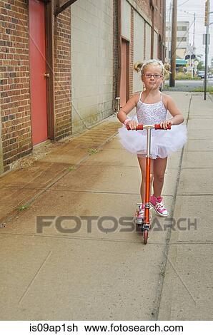 "Young girl wearing tutu and pink baseball boots, using scooter" View Large Photo Image Stock Image - "Young girl wearing tutu and pink baseball boots, using scooter". Fotosearch