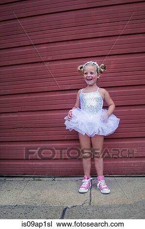 Stock Image - "Young girl wearing tutu and pink baseball boots, plaster on knee". Fotosearch
