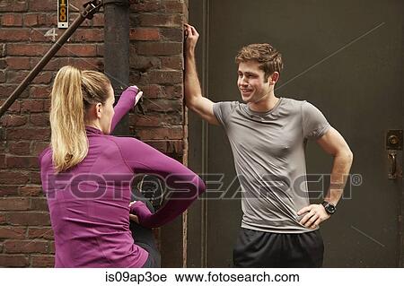 Young male and female runners warming up in alleyway View Large Photo Image Stock Image - Young male and female runners warming up in alleyway. Fotosearch
