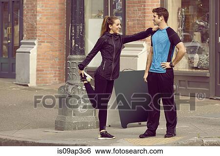 Young male and female runners warming up ion city street View Large Photo Image Stock Photograph - Young male and female runners warming up ion city street. Fotosearch