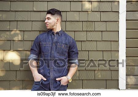 Young man by wall wearing denim shirt View Large Photo Image Stock Image - Young man by wall wearing denim shirt. Fotosearch