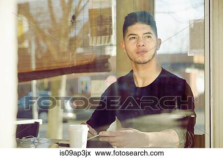 Young man in cafe looking through window View Large Photo Image Stock Photo - Young man in cafe looking through window. Fotosearch