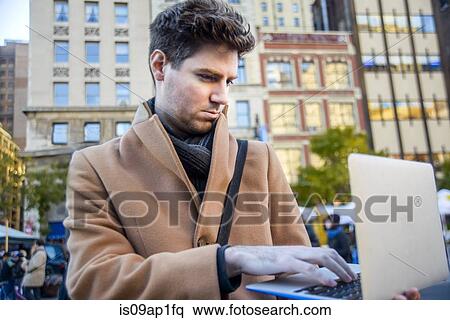"Young man in street, using laptop" View Large Photo Image Stock Photography - "Young man in street, using laptop". Fotosearch