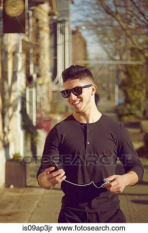 Stock Photography - Young man on street wearing sunglasses. Fotosearch