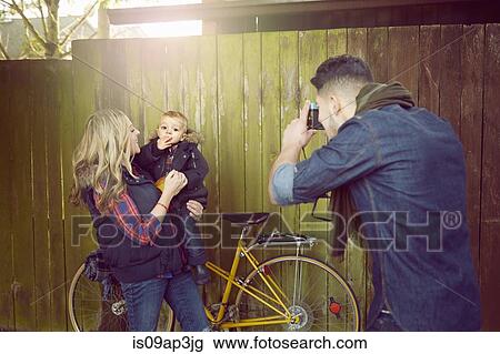 Young man photographing woman with baby boy View Large Photo Image Stock Image - Young man photographing woman with baby boy. Fotosearch