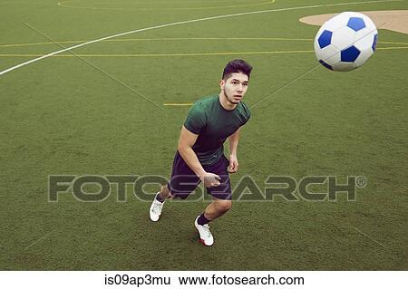 Young man playing soccer on football pitch View Large Photo Image Stock Photograph - Young man playing soccer on football pitch. Fotosearch