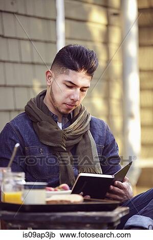 Stock Image - Young man reading book. Fotosearch