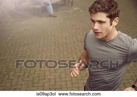 Young man running along sidewalk View Large Photo Image Stock Image - Young man running along sidewalk. Fotosearch
