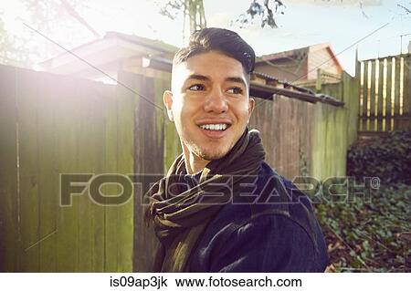 Stock Image - "Young man with quiff looking away, smiling". Fotosearch