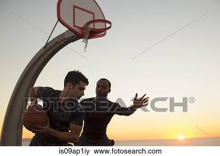 Stock Photo - "Young men playing basketball, outdoors". Fotosearch