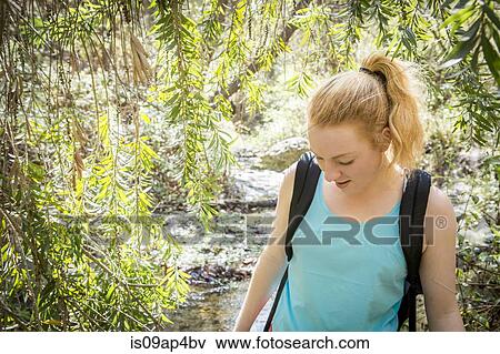 Young woman hiking along riverside View Large Photo Image Stock Photo - Young woman hiking along riverside. Fotosearch