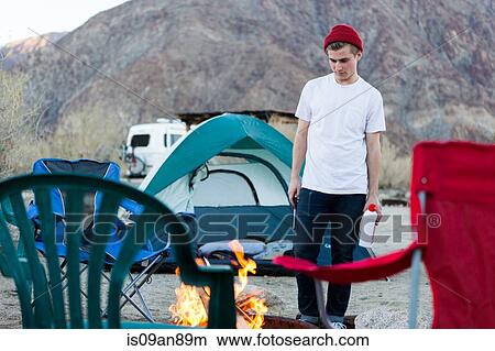 Picture - "Young woman looking down at campfire, Anza-Borrego Desert State Park, California, USA". Fotosearch
