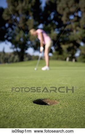 "Young woman playing golf, focus on foreground" View Large Photo Image Picture - "Young woman playing golf, focus on foreground". Fotosearch