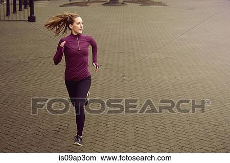 Young woman running along sidewalk View Large Photo Image Picture - Young woman running along sidewalk. Fotosearch