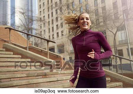 Stock Photography - "Young woman running along street, Pioneer Square, Seattle, USA". Fotosearch