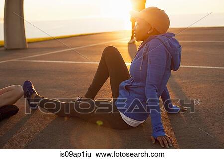 "Young woman sitting on basketball court, outdoors" View Large Photo Image Stock Photograph - "Young woman sitting on basketball court, outdoors". Fotosearch