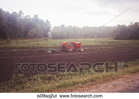 A tractor in a field View Large Photo Image Stock Photograph - A tractor in a field. Fotosearch