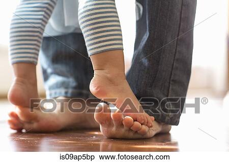 Baby daughter standing on father's feet View Large Photo Image Stock Photography - Baby daughter standing on father's feet. Fotosearch